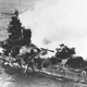 The heavily damaged Mikuma lies dead in the water shortly before sinking. The wreckage of an American Vought SB2U Vindicator dive bomber lies on top of the aft gun turret. (US Navy)